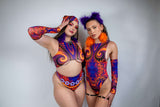 Two models showcasing vibrant rave outfits with intricate patterns in purple and orange colors.
