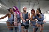 A group of five friends wearing matching black and white rave outfits. The women are wearing rave bodysuits and the man is wearing a tank top.