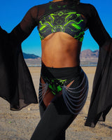 raver adorns vibrant black and green electronic festival outfit with the desert scenery as backdrop