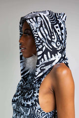 A photo of the side of a girl's head. She is wearing a black and white tribal printed hood over her head and a matching bodysuit.