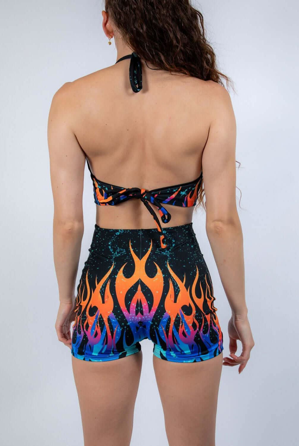 Back view of the Blaze Romper showcasing its fiery print and halter neckline, ideal for rave outfits.