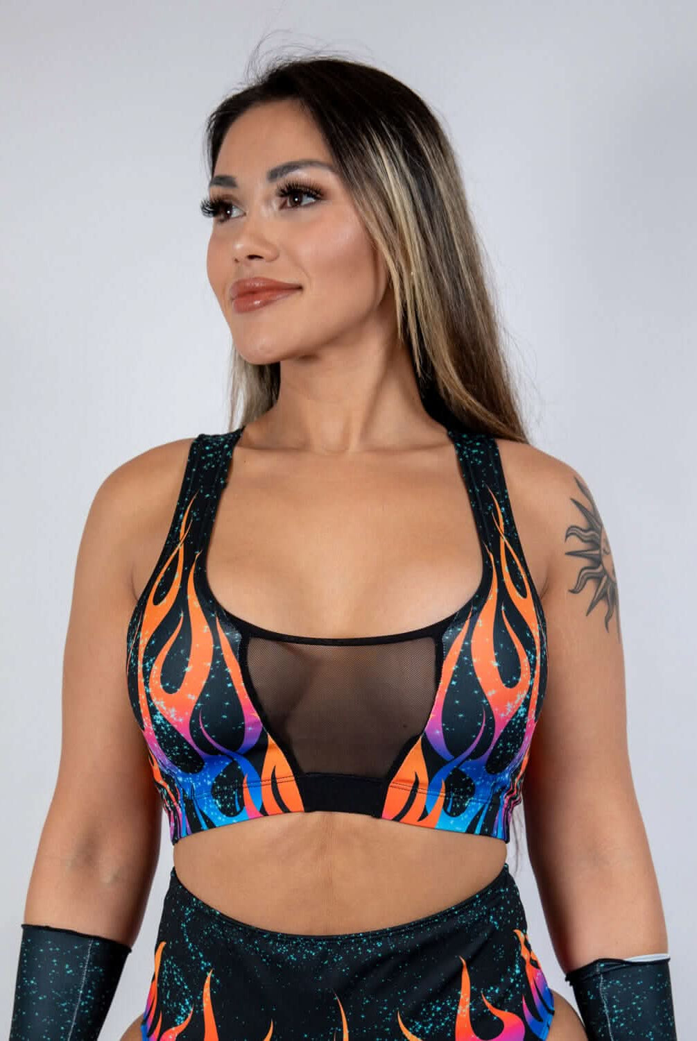 Woman wearing Blaze V Free Top with flame print and mesh V-panel, perfect for rave outfits.