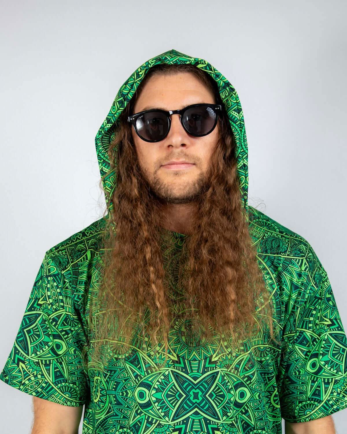 Model wearing a green Dominion Assassin Hood and sunglasses, showcasing a vibrant rave outfit.