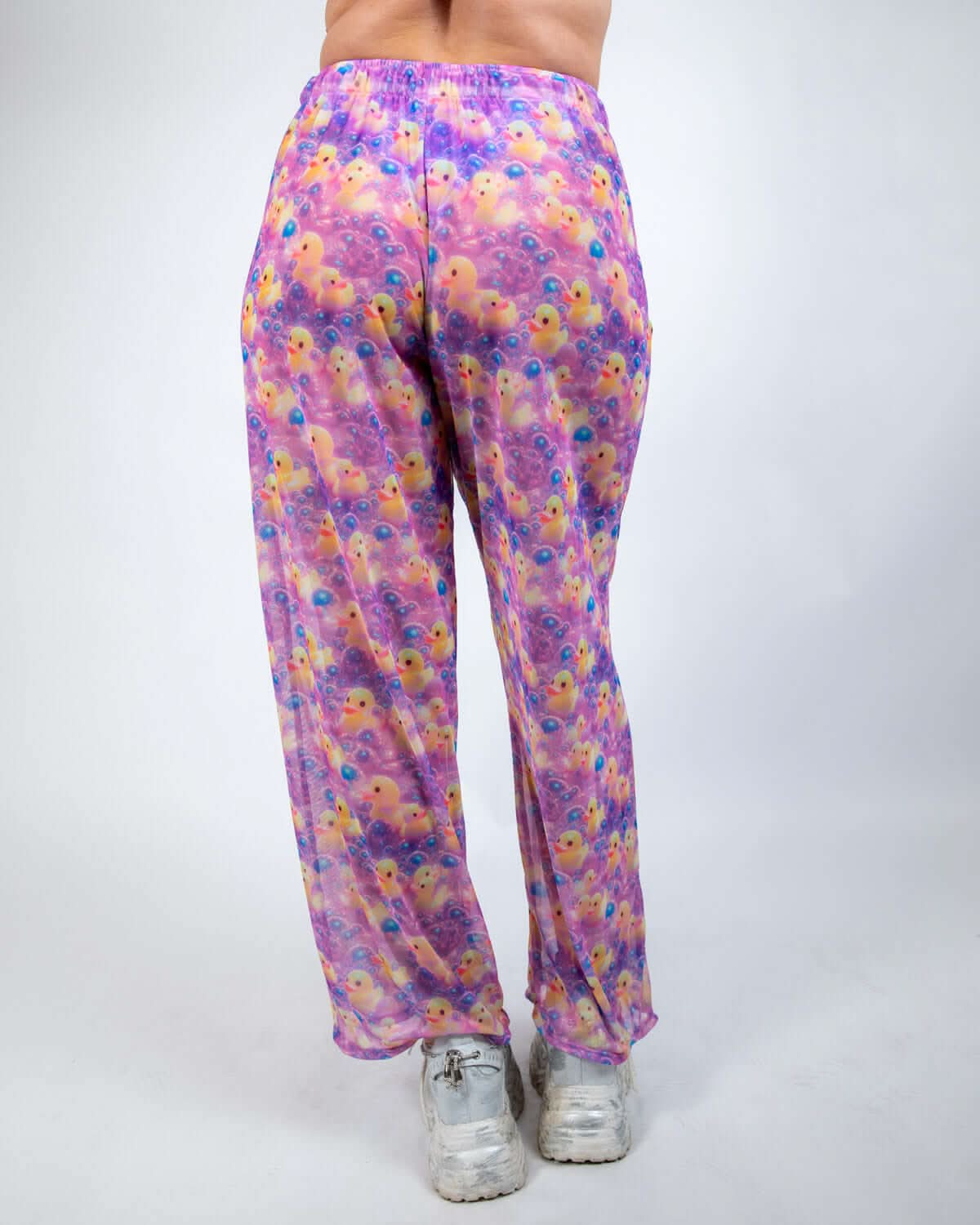 Back view of Duckies Mesh Lucy Pants in vibrant purple, yellow, and pink, ideal for rave outfits with wide-leg design.