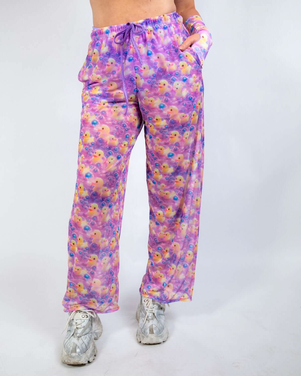 Duckies Mesh Lucy Pants in vibrant purple, pink, and yellow print, perfect for rave outfits with wide-leg flow and comfortable waistband.