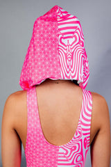 A woman facing away from the camera wearing a pink and white bodysuit with a matching hood.