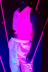 A man wearing a pink and white tank top with a hood and matching pants. His clothes glow under black light.