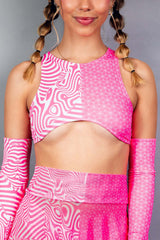 A woman wearing a pink and white crop top with a matching skirt.