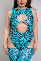 A woman wearing a blue and black swirled bodysuit with two keyhole cutouts and matching leg sleeves.