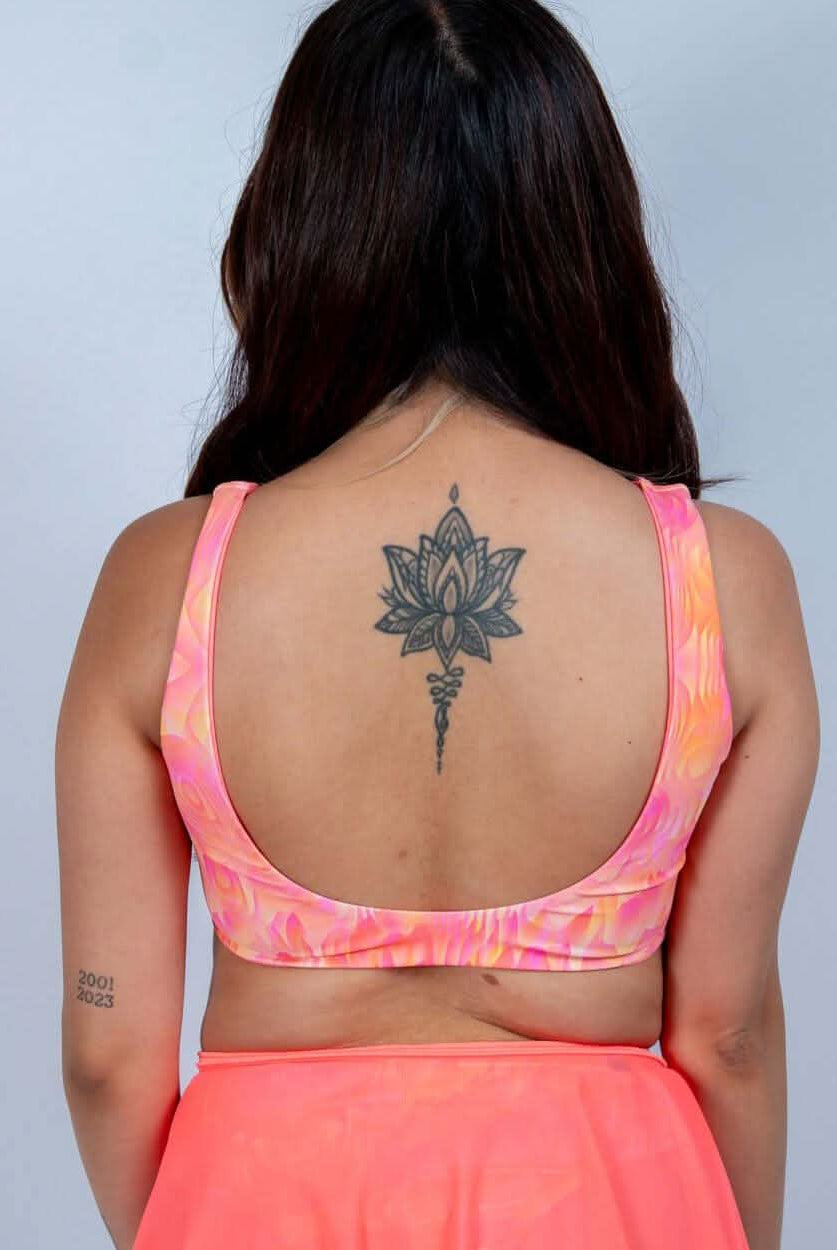 Back view of a woman in a pink Fire Drift Bikini Top, showcasing its thick straps and molten swirl print.