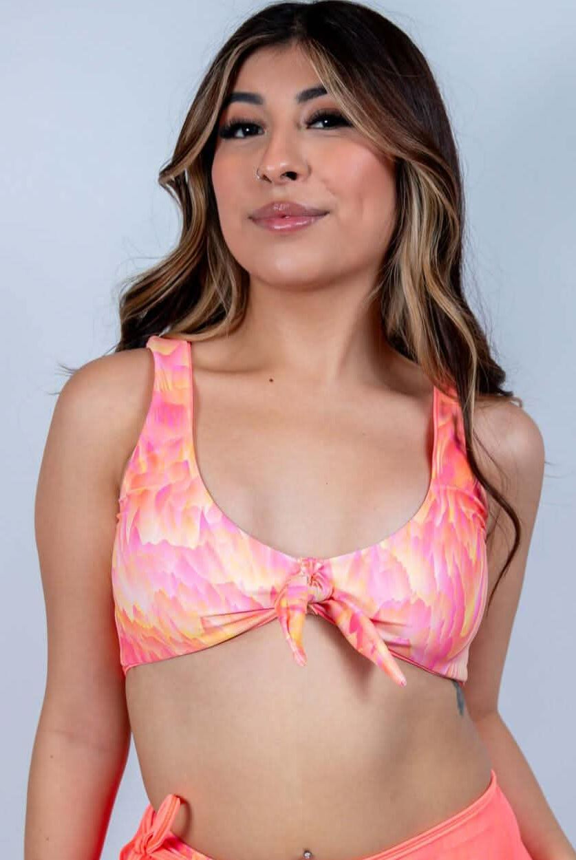 Model wearing the Fire Drift Bikini Top in a vibrant molten swirl print, perfect for rave outfits.