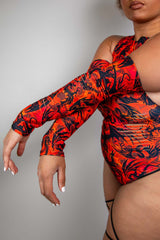 Close-up of arm sleeves on a vibrant orange and black Freedom Rave Wear bodysuit featuring detailed flame designs, emphasizing a fierce and fiery rave fashion statement.