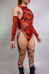 Dynamic side view of a model in a vibrant orange and black Freedom Rave Wear bodysuit with elaborate patterns.