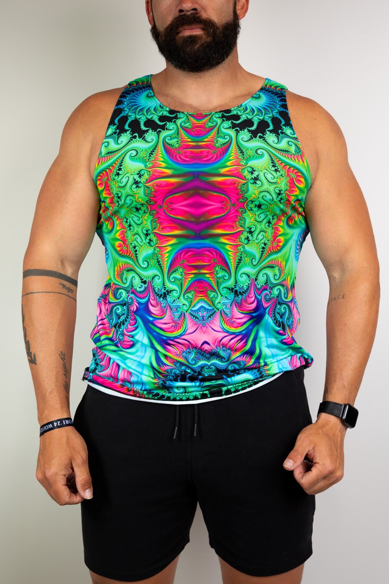  Model wearing a vibrant, psychedelic tank top with colorful patterns, ideal for raves. Freedom Rave Wear offers unique festival fashion.