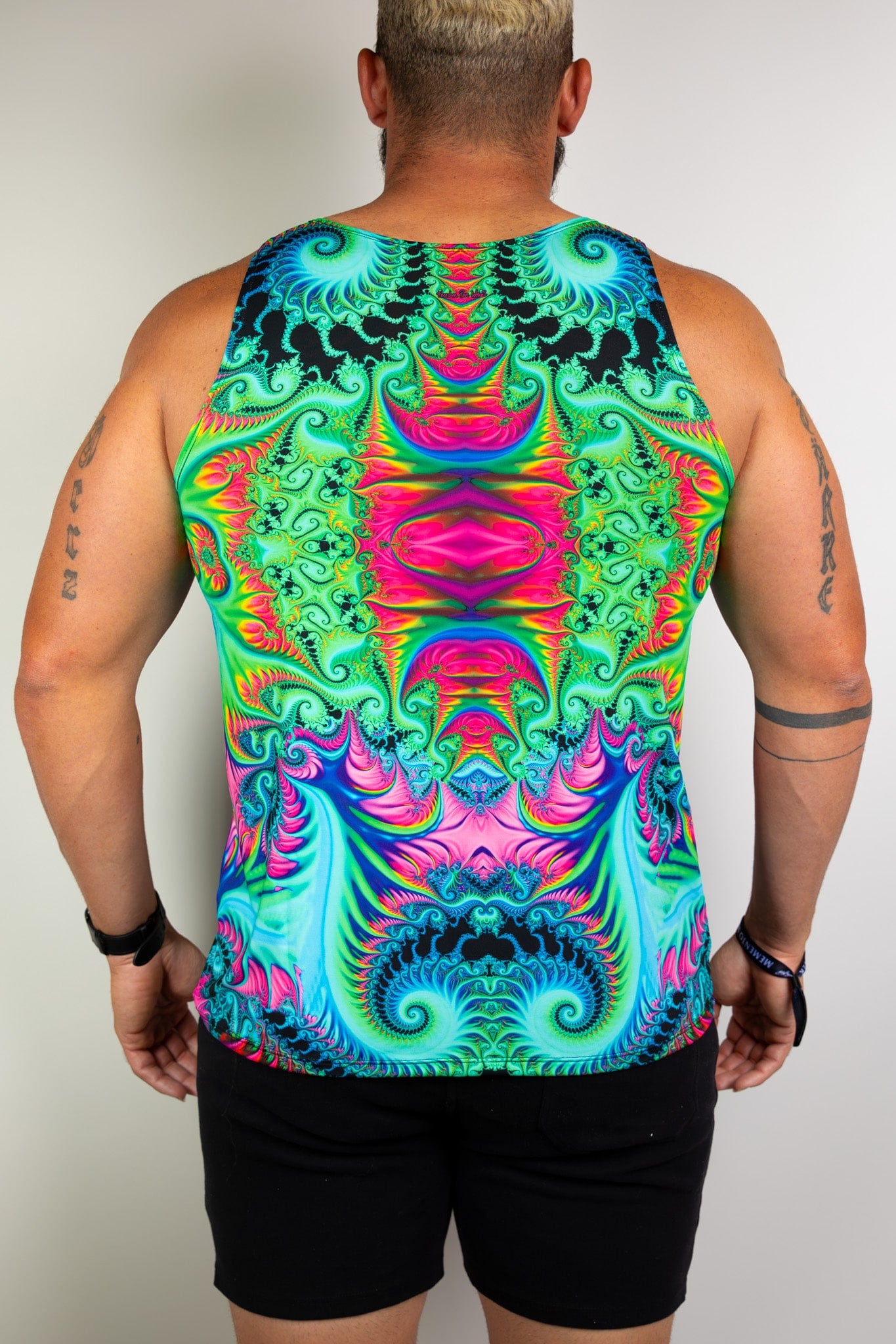 Model showing the back view of a colorful psychedelic tank top with intricate patterns, ideal for rave events. Freedom Rave Wear elevates festival fashion. 