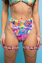An up close photo of a woman wearing rainbow bikini bottoms with whimsical characters printed on them.