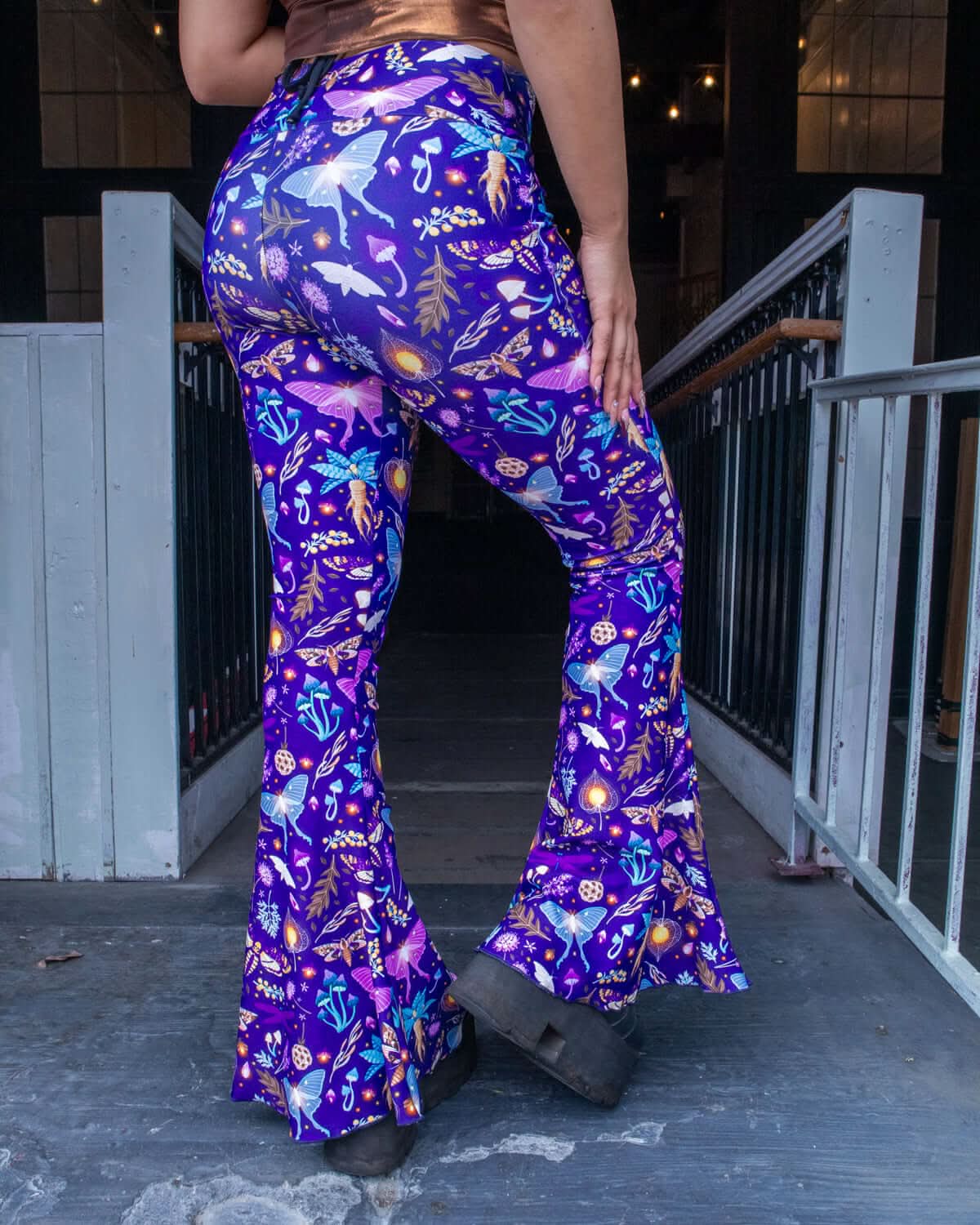 Lucent Bell Bottoms showcasing a vibrant bioluminescent print, perfect for rave outfits, with high-rise waist and dramatic flare.