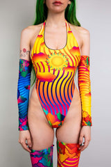 Model poses in a striking Freedom Rave Wear sun-themed halter bodysuit paired with vibrant arm and leg sleeves.
