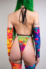 Rear view of a Freedom Rave Wear sun-themed halter bodysuit, featuring colorful arm sleeves and striking green hair