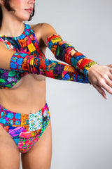 A photo of a girl's arms, wearing rainbow patchwork sleeves.
