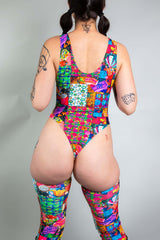An up close photo of a girl wearing a rainbow patchwork bodysuit. She is facing away from the camera.