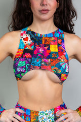 An up close photo of a woman wearing a rainbow patchwork crop top.