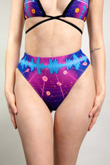 An up close photo of a woman wearing a neon synthwave patterned rave bikini.