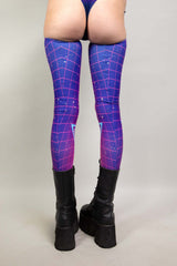 A woman's legs, facing away from the camera, wearing leg sleeves with a pink and purple geometric pattern.