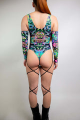 Model wearing Freedom Rave Wear’s vibrant bodysuit with psychedelic patterns, showcasing detailed back cutouts.