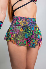 Model wearing a colorful Freedom Rave Wear mesh micro skater skirt, highlighting intricate floral and psychedelic designs.
