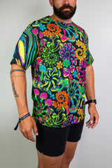 Model showcasing a vibrant, psychedelic floral t-shirt with bold patterns, ideal for raves. Freedom Rave Wear offers unique festival fashion. 