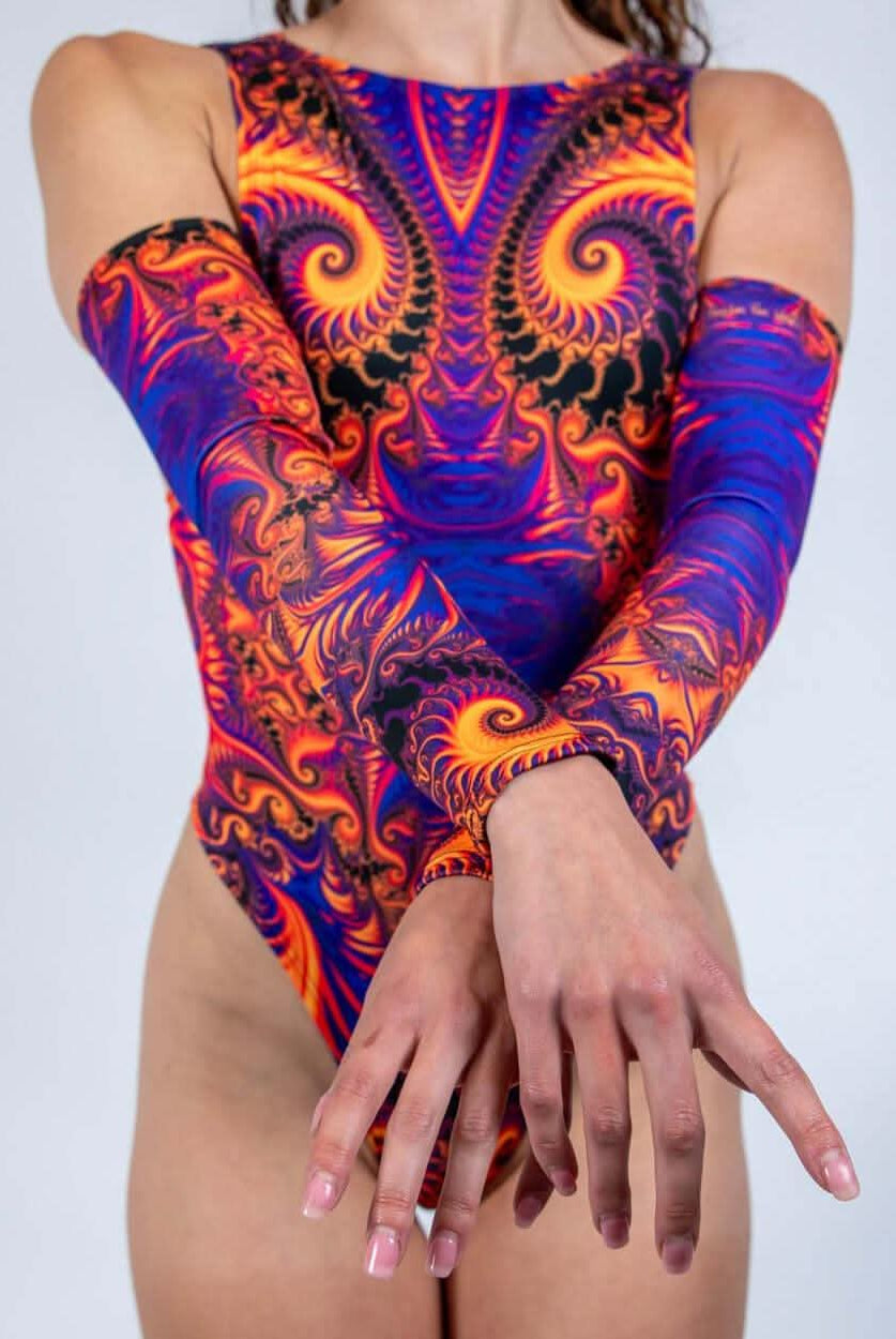 Model showcasing Radiance Arm Sleeves with vibrant fractal patterns in orange and purple, ideal for rave outfits.