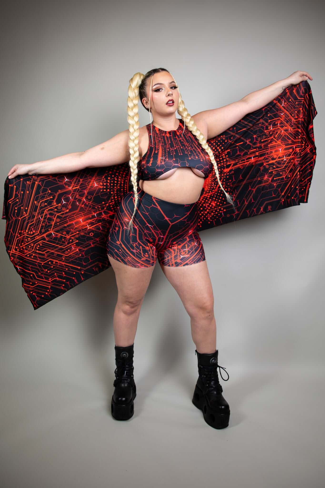 Model confidently displays Freedom Rave Wear circuit-pattern outfit and pashmina, highlighted by braided hair and chunky black boots