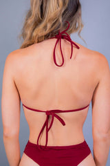 Back view of a woman in a strappy scarlet bikini top from Freedom Rave Wear, ideal for festival style.