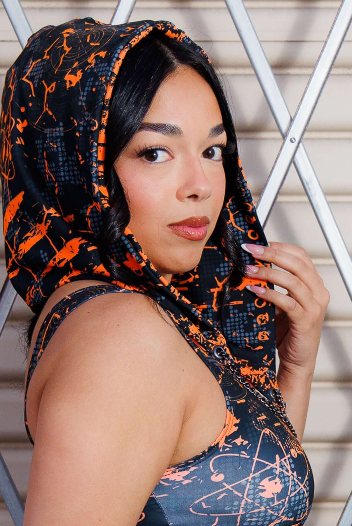 Model wearing Atomic Assassin Hood in orange and black, showcasing a post-apocalyptic, dystopian style with a warrior vibe.