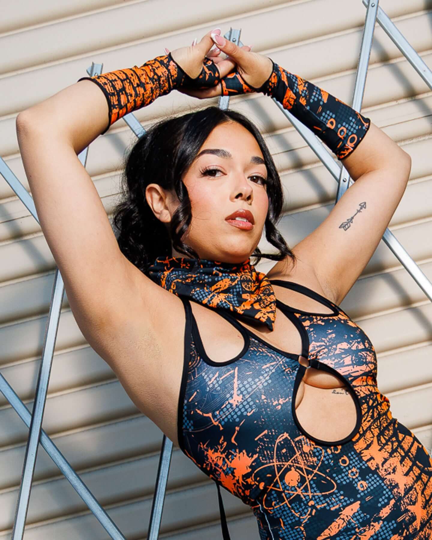 Model wearing Atomic Gloves, featuring flame-meets-galaxy print, in a stylish pose against a geometric background.