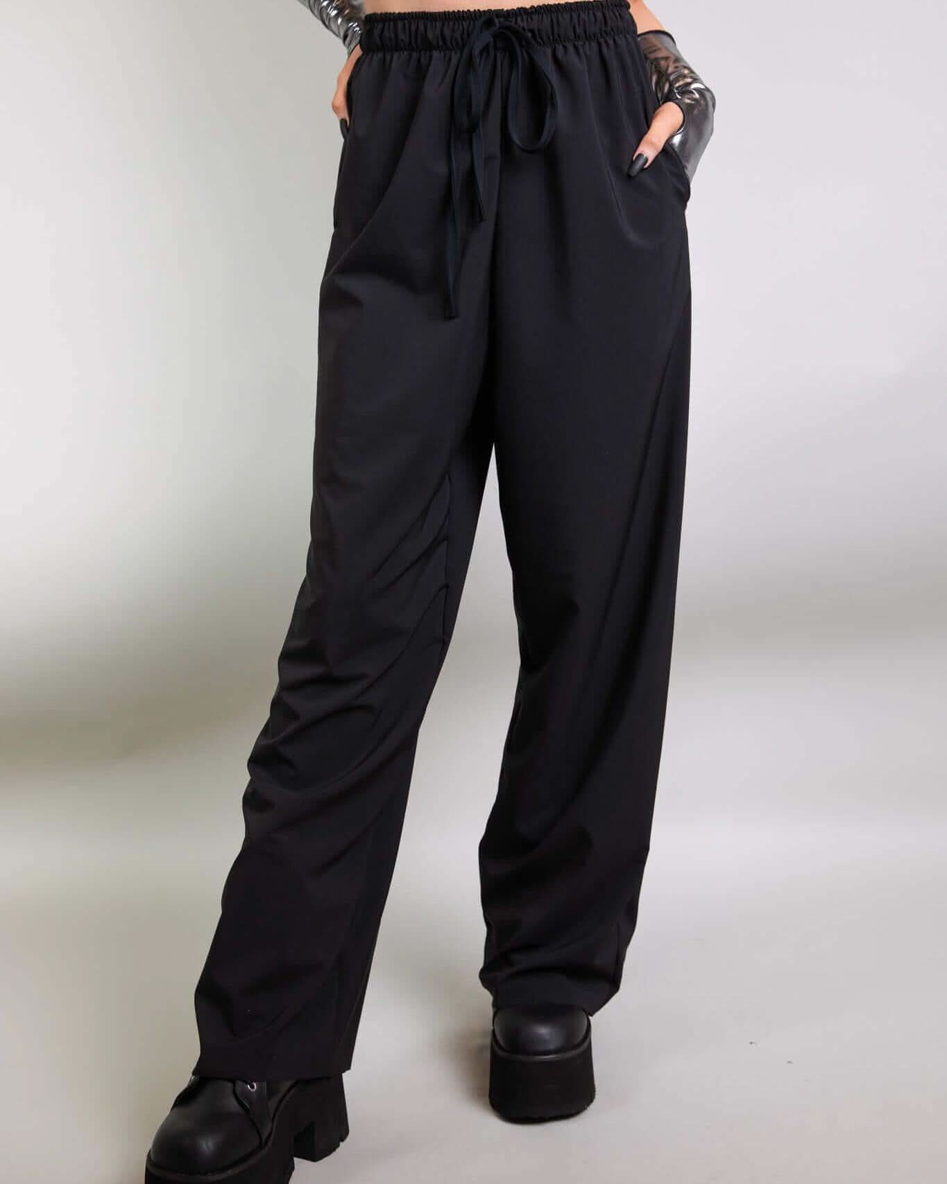 Model wearing Black Lucy Pants, showcasing wide-leg design and elastic waistband, perfect for rave outfits.