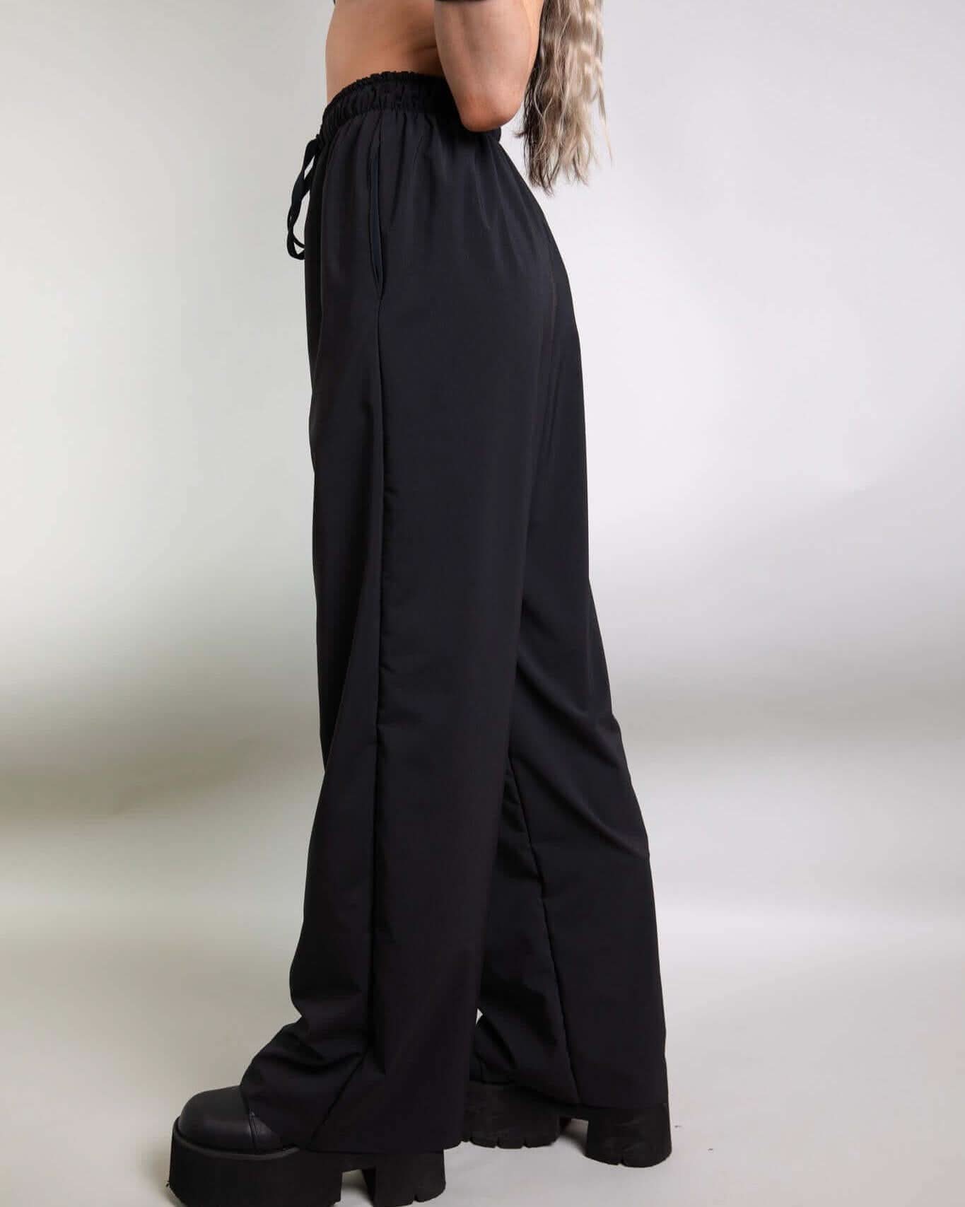 Black Lucy Pants featuring loose wide legs and elastic waistband, perfect for rave outfits and all-night dancing.