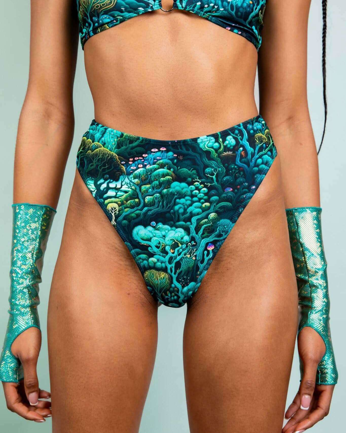 Model wearing Faewood High Waisted Thong with forest print, styled with matching glitter sleeves for a rave-ready look.