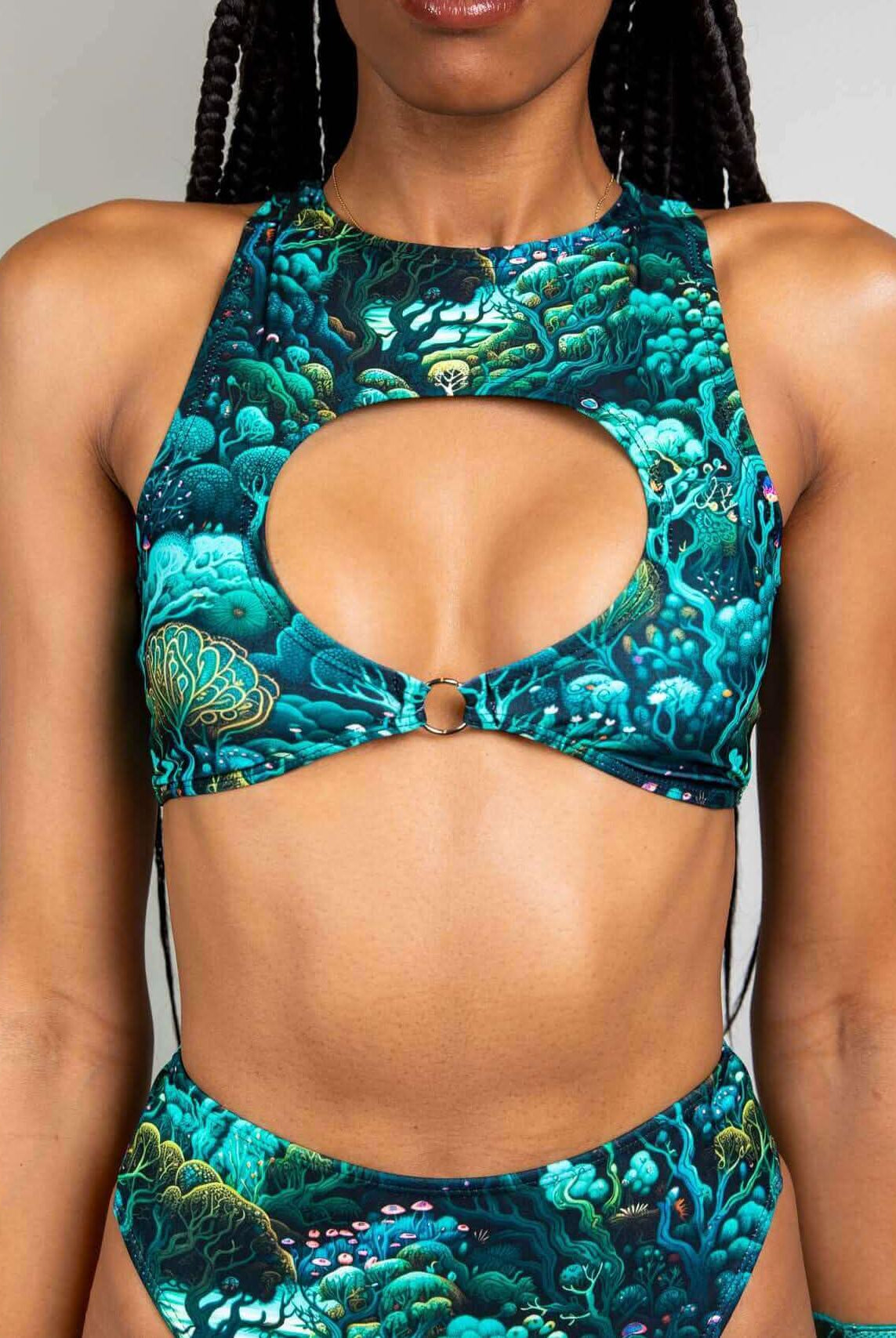 Model wearing Faewood Keyhole Top with O-ring detail, showcasing vibrant forest print, perfect for rave outfits.