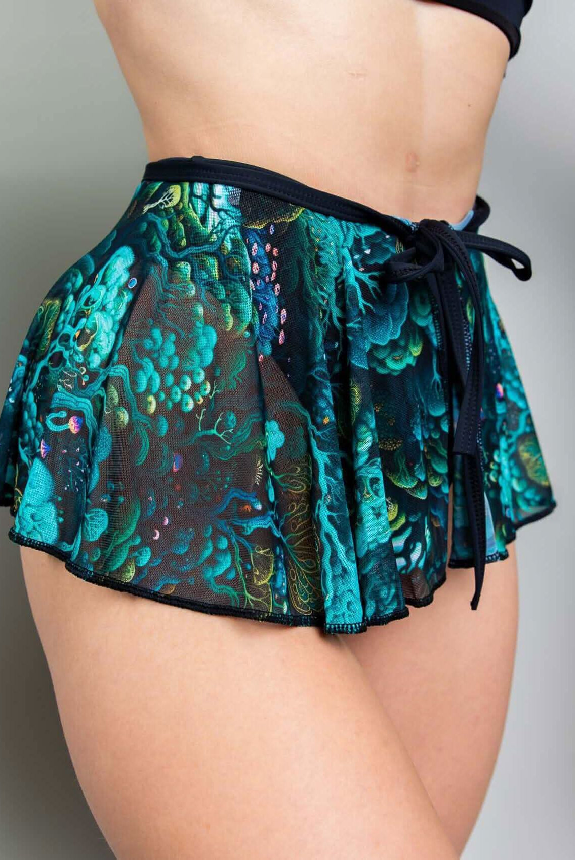 Faewood Mesh Swirl Skirt featuring a vibrant pattern, tied at the waist, perfect for rave outfits and stylish layering.