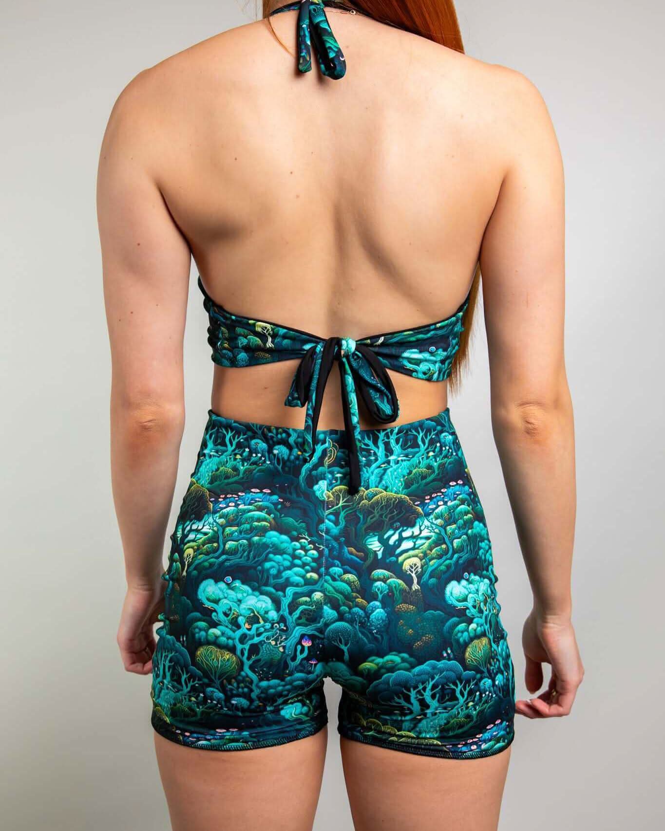 Back view of a woman wearing the Faewood Romper with an enchanted forest design, perfect for rave outfits.