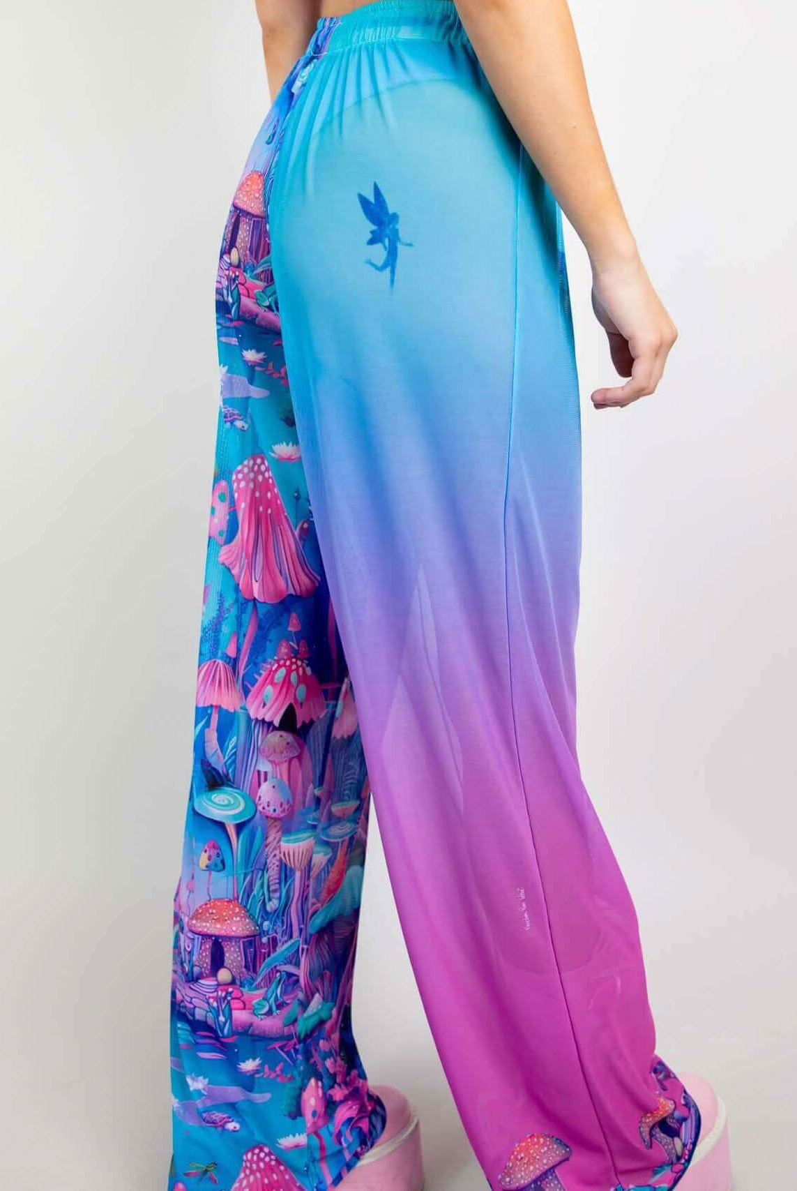 Model wearing Fairycore Mesh Lucy Pants with colorful mushroom print and gradient design, perfect for rave outfits.