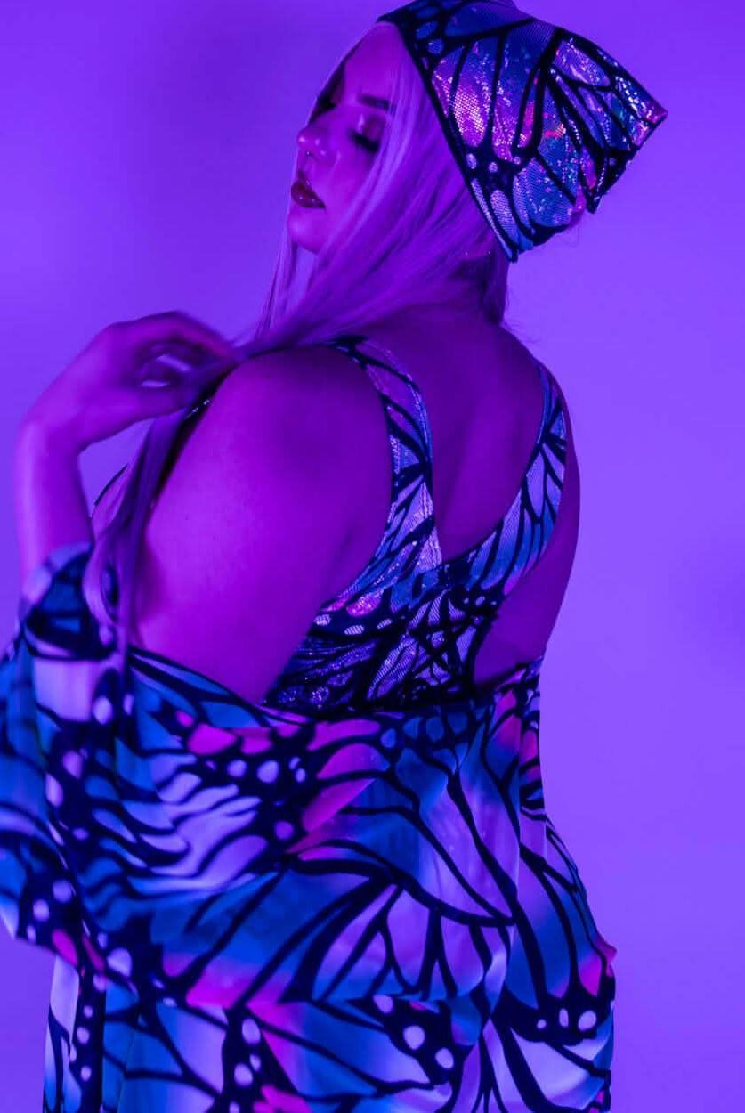 Model showcasing a holographic butterfly bandana in vibrant colors, perfect for rave outfits and festival clothing.