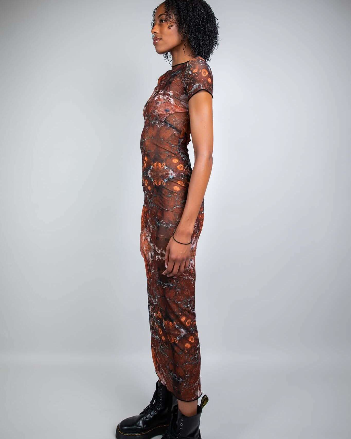 Side view of a model wearing the Fossil Mesh Baby Tee Maxi Dress, showcasing a form-fitting silhouette and stylish footwear.