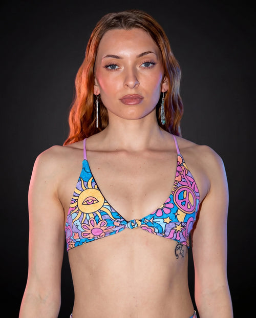 Groovy Serendipity Top front view, showcasing the pastel rave bikini top with peace signs, daisies, and a third-eye sun.