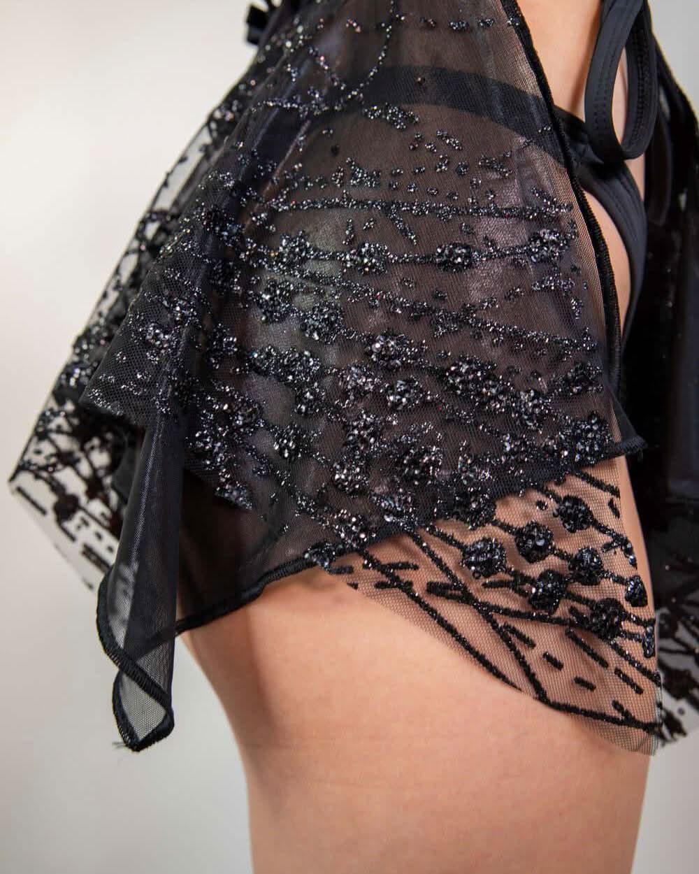 Side view of the Lilith Fairy Skirt, showcasing its flowy black sparkly fabric and layered design.