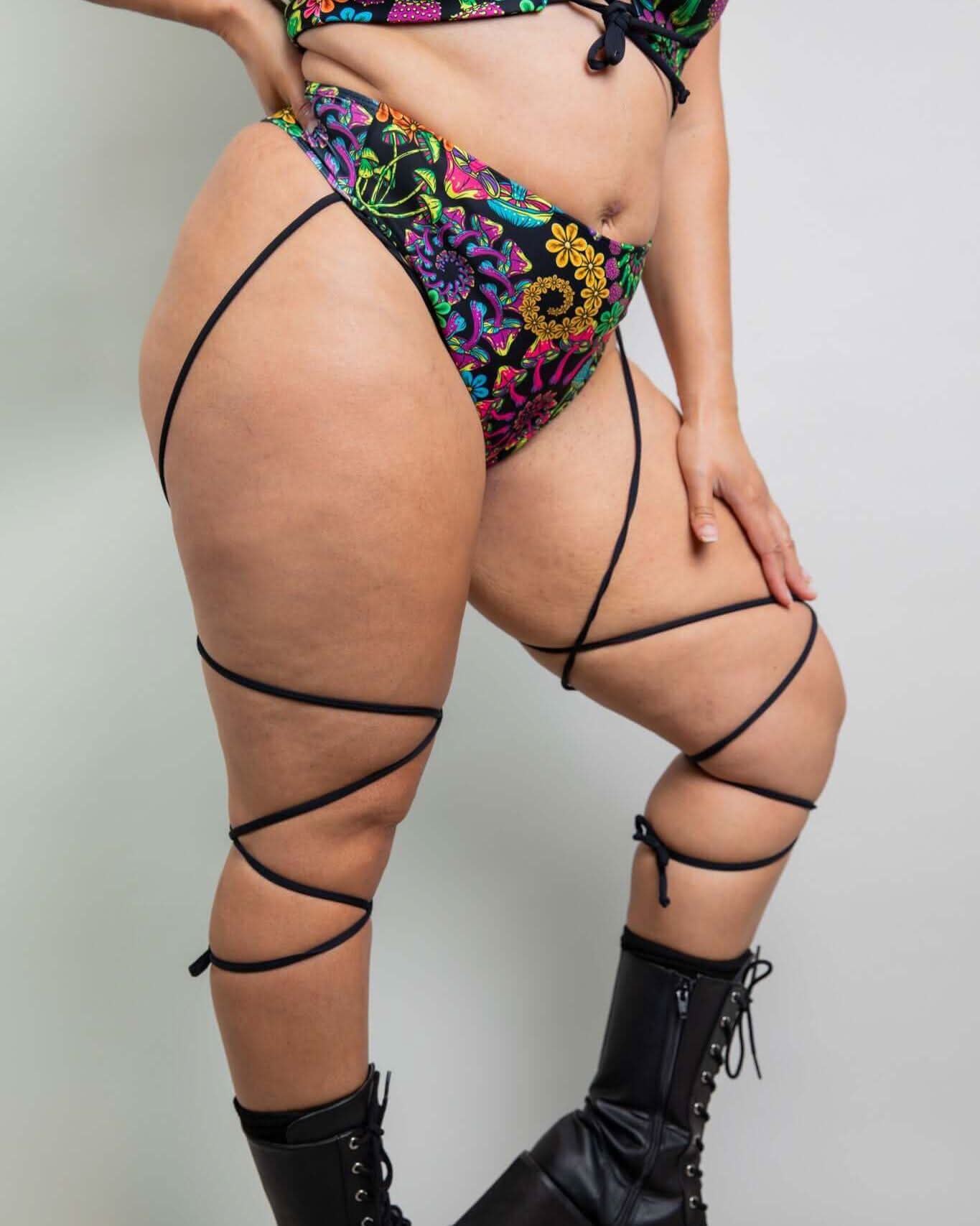 Model in colorful PsyBloom Strappy High Waisted Thong and lace-up boots, showcasing a vibrant rave outfit.