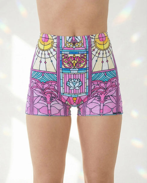 Moonlight High Waist Shorts in a pastel stained-glass pattern, featuring crescent moons and a blue lotus, modeled from the front for a rave festival look.
