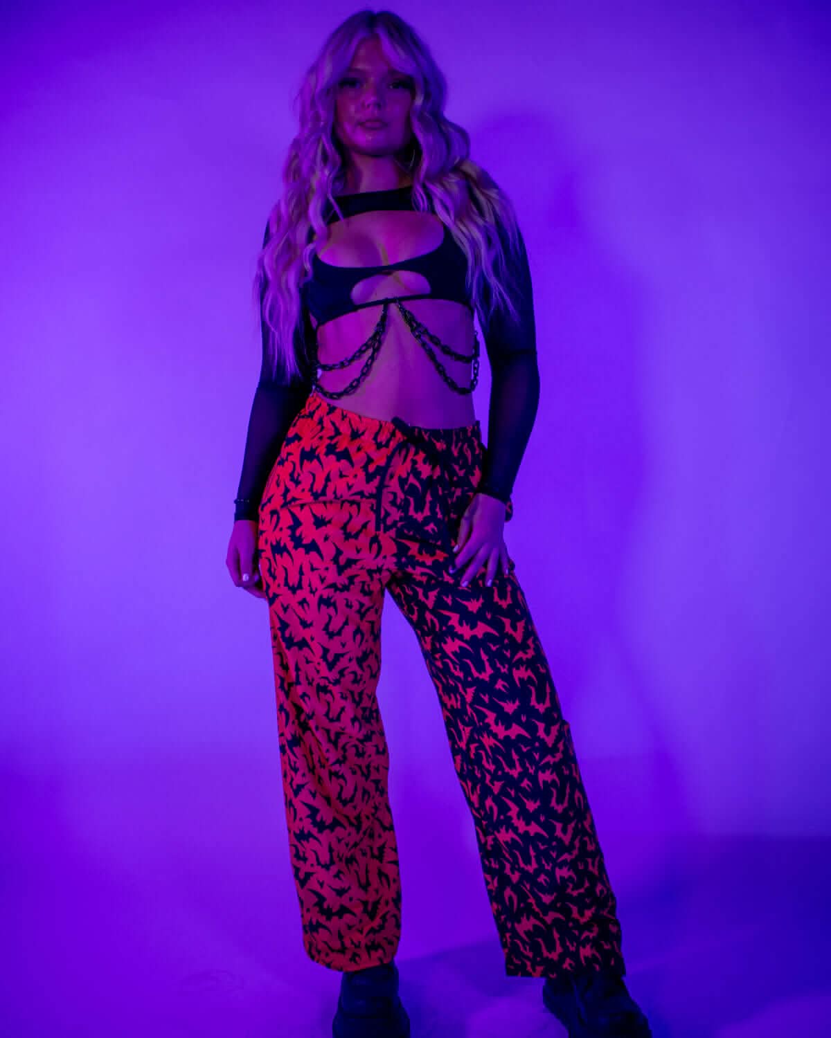 Model wearing Red Batty 50/50 Lucy Pants - UV Red, showcasing a unique design with bright colors under blacklight.
